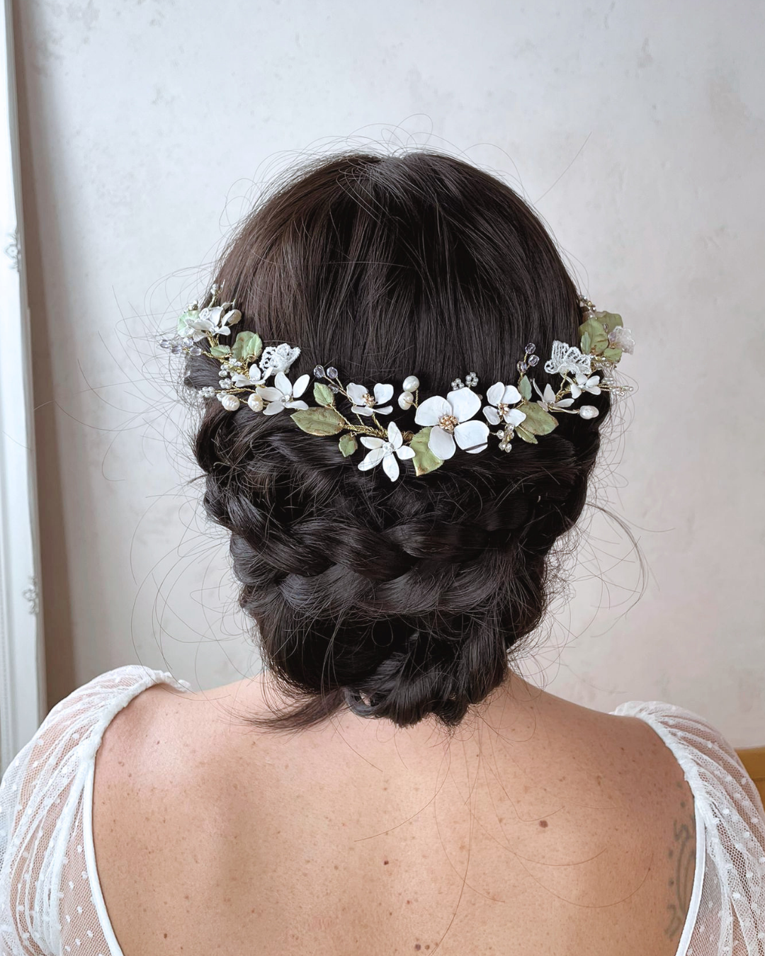 Dettaglio sui fiori bianchi texturizzati e i delicati inserti in pizzo che donano un fascino rétro e preraffaellita al gioiello.