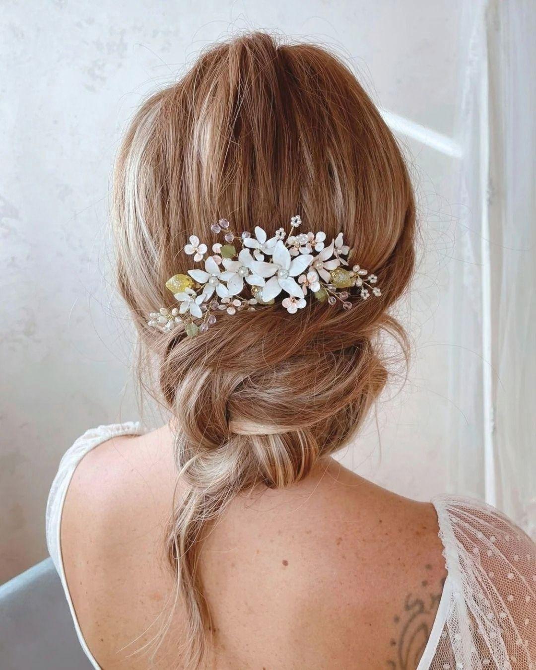 Vista posteriore del pettinino floreale posizionato sopra uno chignon morbido