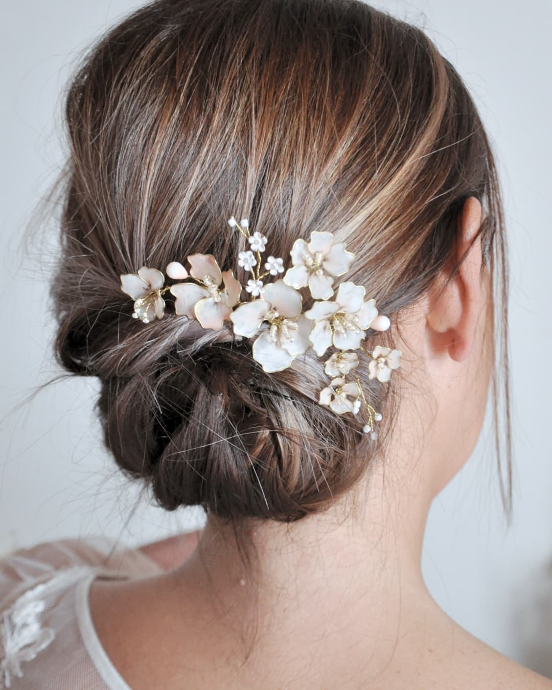 Dettaglio artigianale del pettinino Fiori di Ciliegio con petali smaltati e finitura oro.