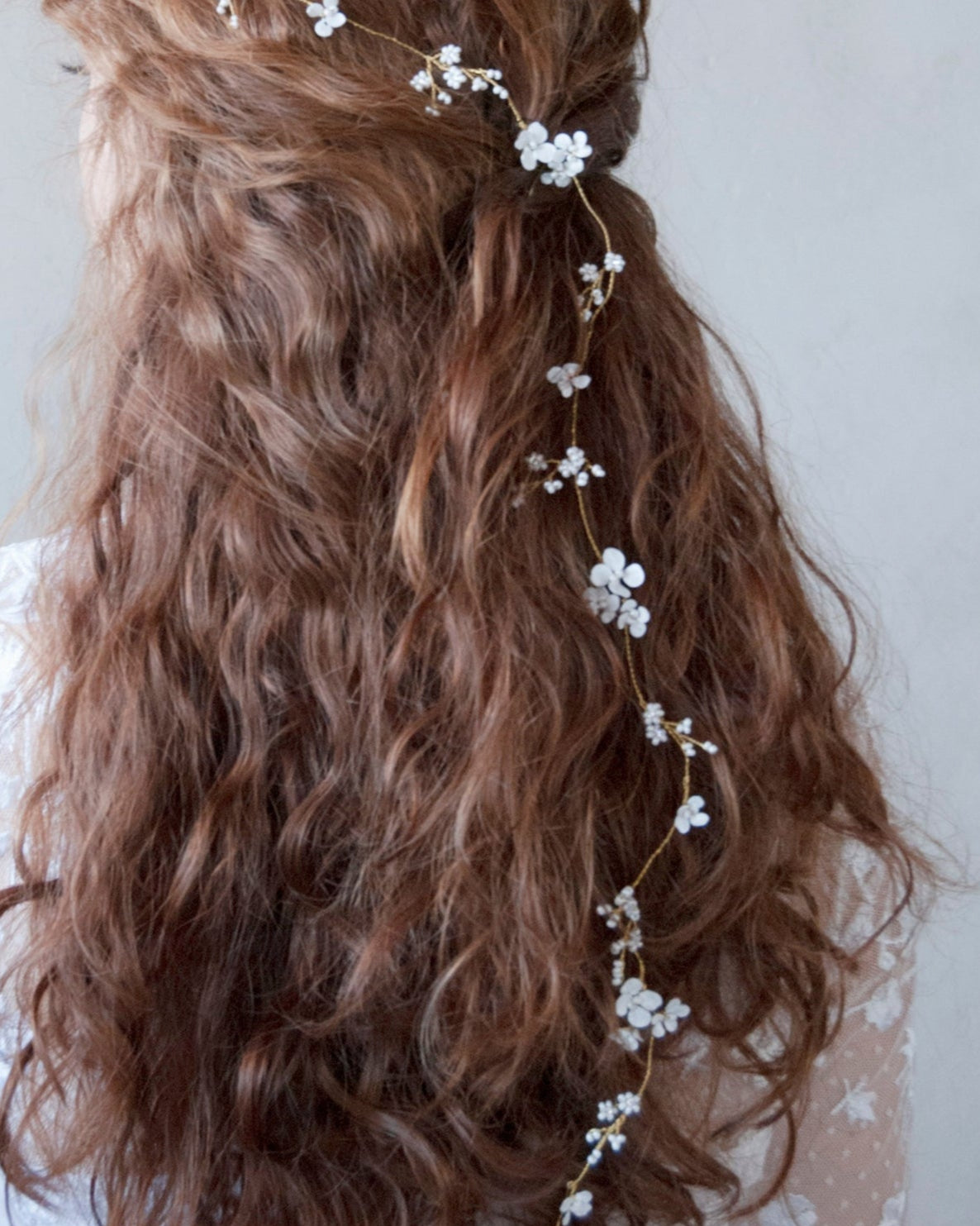 Accessorio floreale per capelli, decorato con fiorellini bianchi delicati.