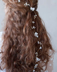 Accessorio floreale per capelli, decorato con fiorellini bianchi delicati.