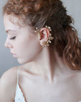 Accessorio orecchio: ear cuff dorato con design floreale delicato.