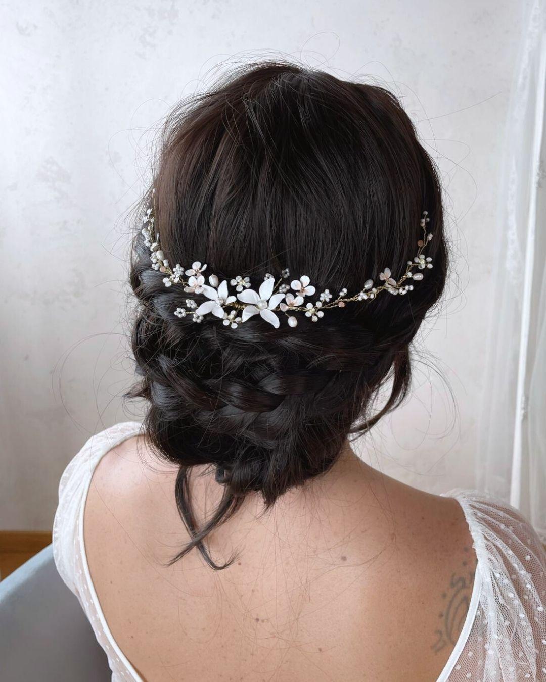 Elegante chignon da sposa impreziosito dal fermaglio modellabile Neroli con dettagli floreali e perle.