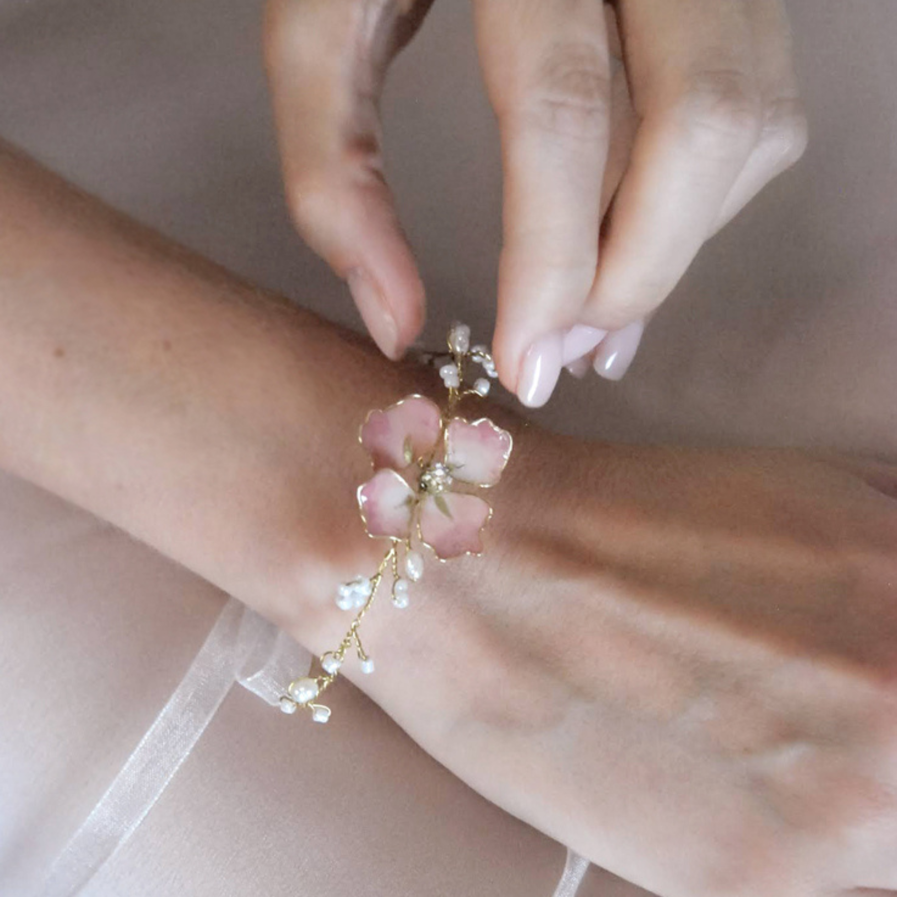 Bracciale da sposa in oro con fiore rosa e dettagli luminosi, perfetto per un tocco elegante.