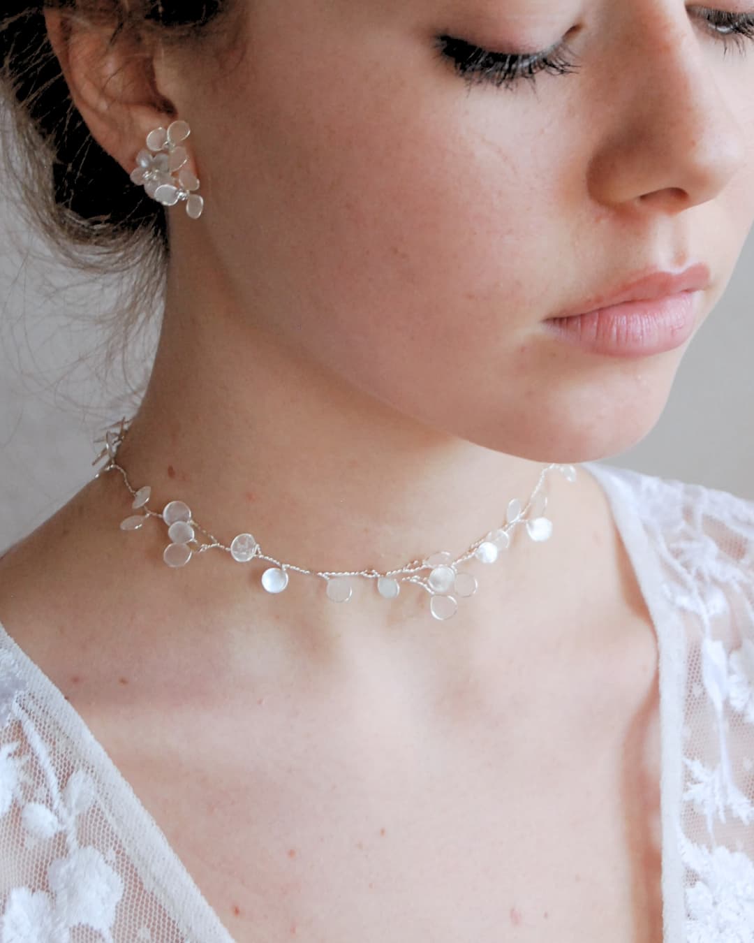 Choker artigianale Perla di Luna con petali in madreperla e nastro in seta, per un'eleganza nuziale contemporanea.