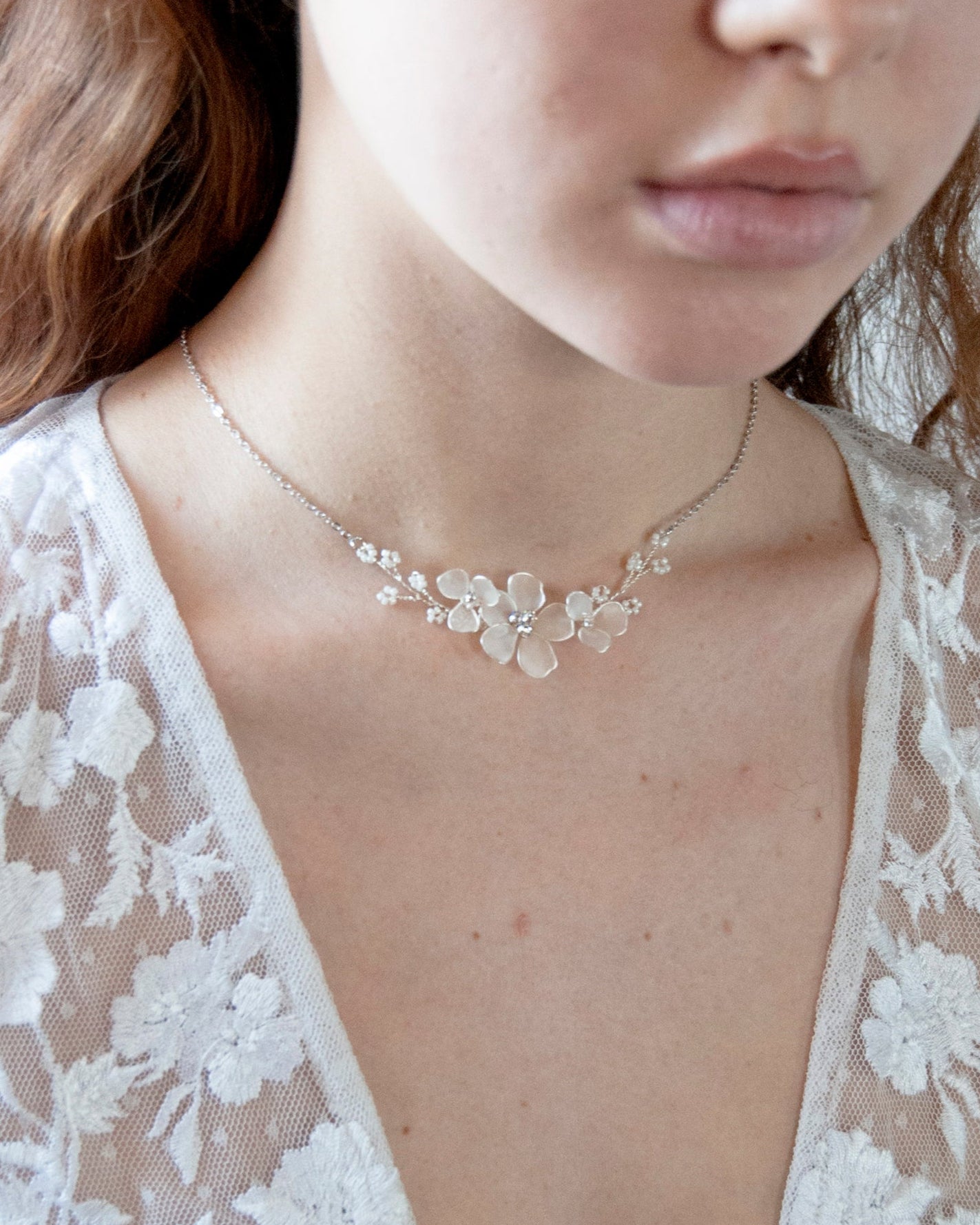 Accessorio elegante: collana con fiori satinati per un look sofisticato.