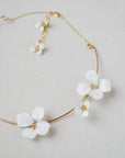 Collana rigida con fiori bianchi, accessorio unico e delicato, perfetto per il matrimonio e per aggiungere eleganza al look da sposa.