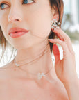 Collana rigida con fiori madreperla, un dettaglio elegante e delicato per il look da sposa.