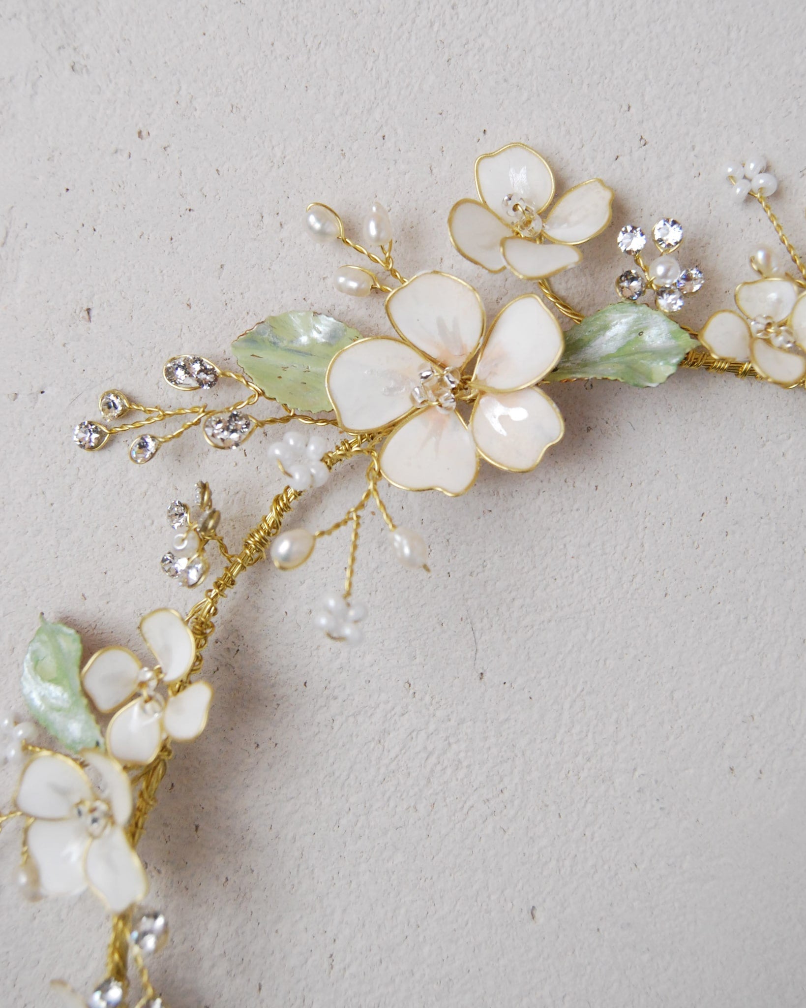 Corona di fiori rosa e foglie verdi, un’ottima alternativa ai fiori freschi per un matrimonio boho-chic.