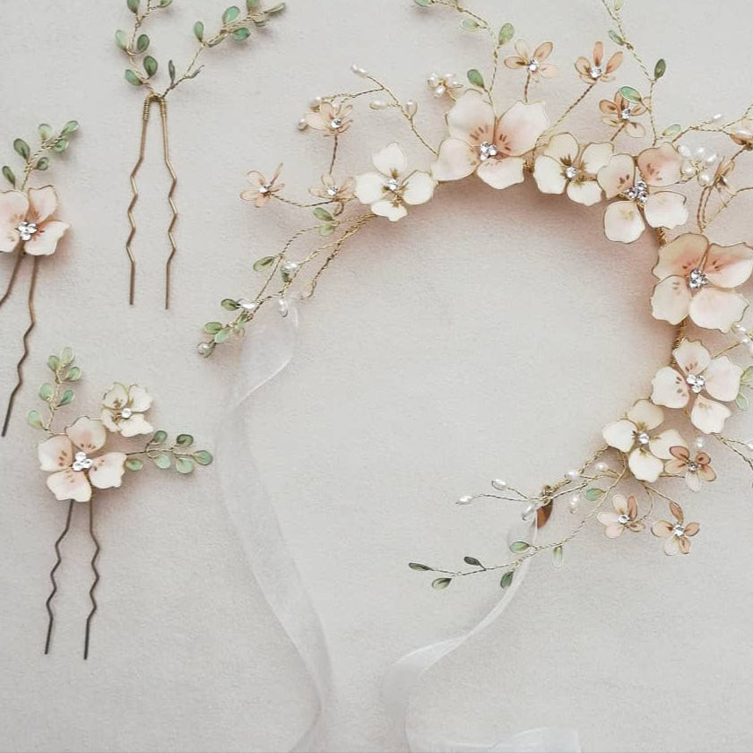 Coroncina da sposa con fiori rosa e foglie verdi, accessorio romantico e naturale.