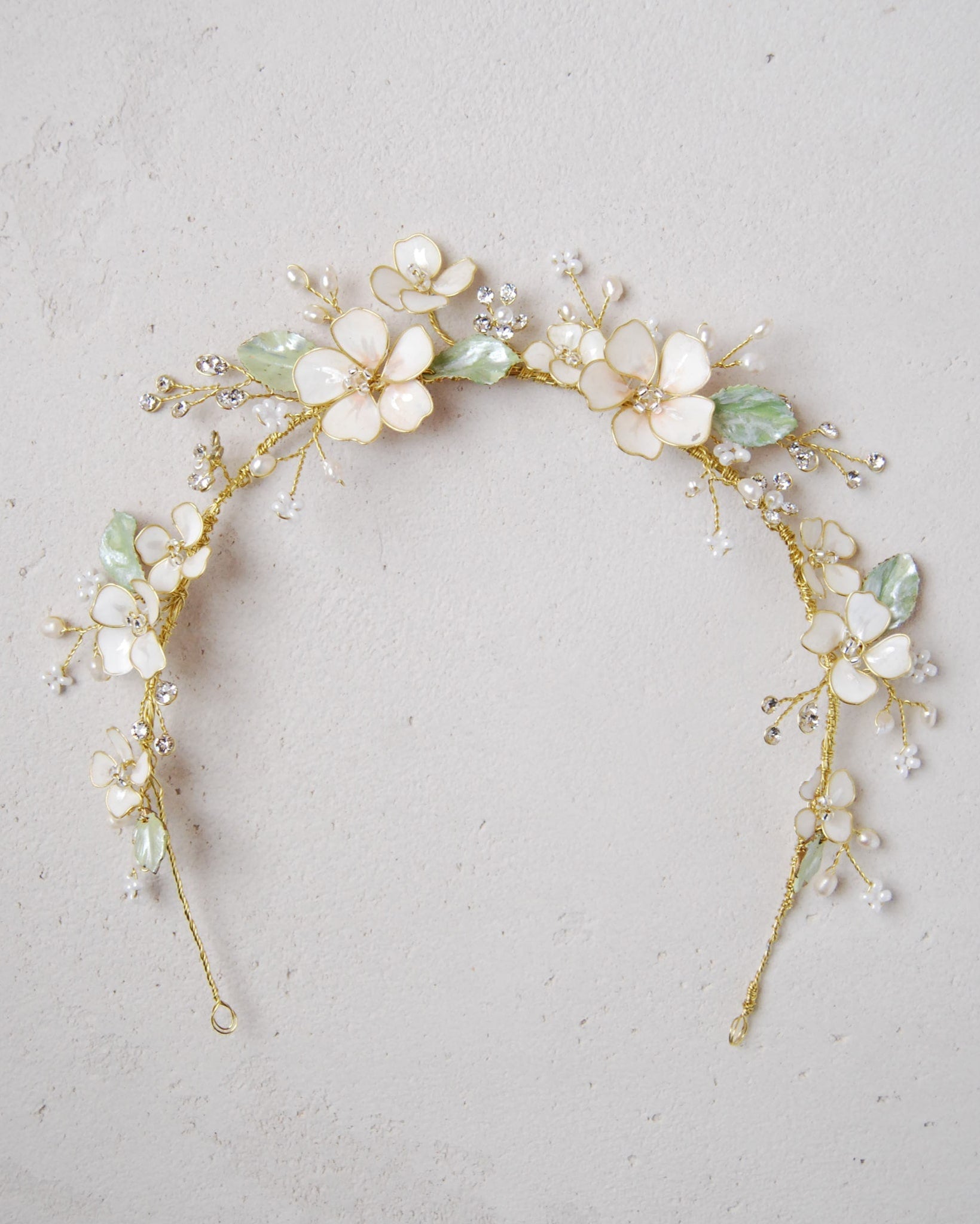 Coroncina da sposa con fiori rosa e foglie verdi, perfetta per un'acconciatura boho-chic e naturale.