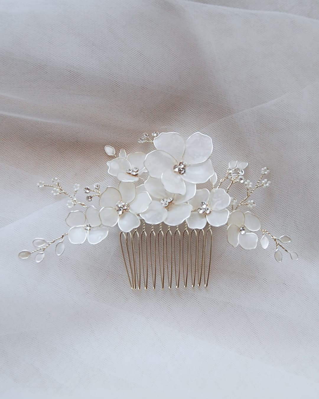 Primo piano dei cristalli Swarovski e dei fiori satinati del pettinino d'alta gamma Frostalia.