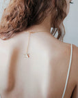 Dettaglio unico della collana Lieve: un piccolo fiore coordinato che cade elegantemente sulla schiena nuda.
