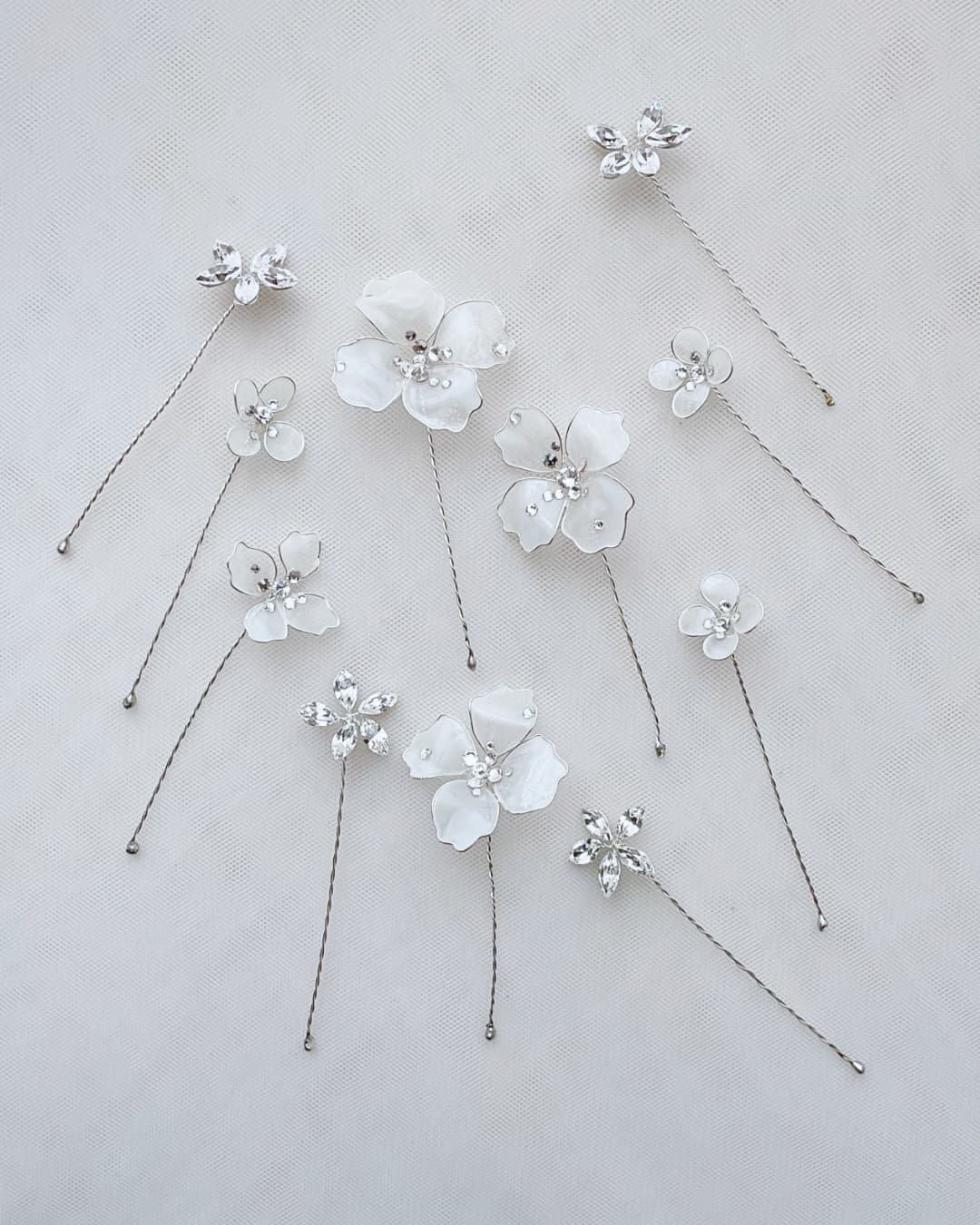 Dettaglio macro dei fiori bianchi lucidi con cuore in cristallo Swarovski® e rami modellabili argento.