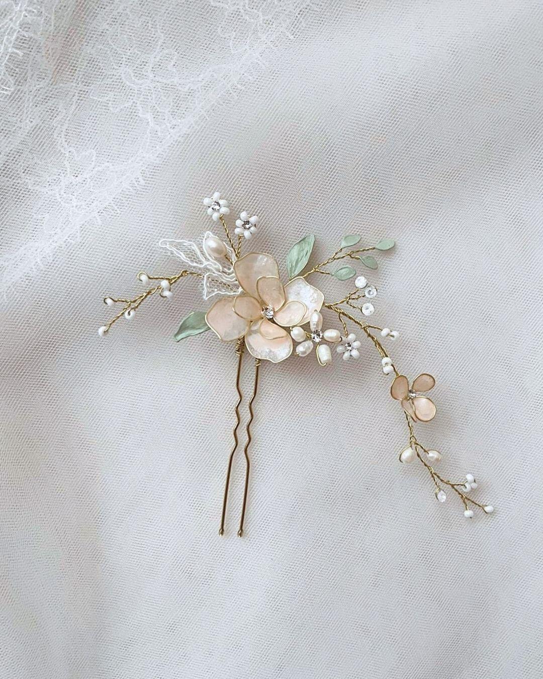 Dettaglio ravvicinato della forcina con pizzo e con fiori e piccoli cristalli luminosi.