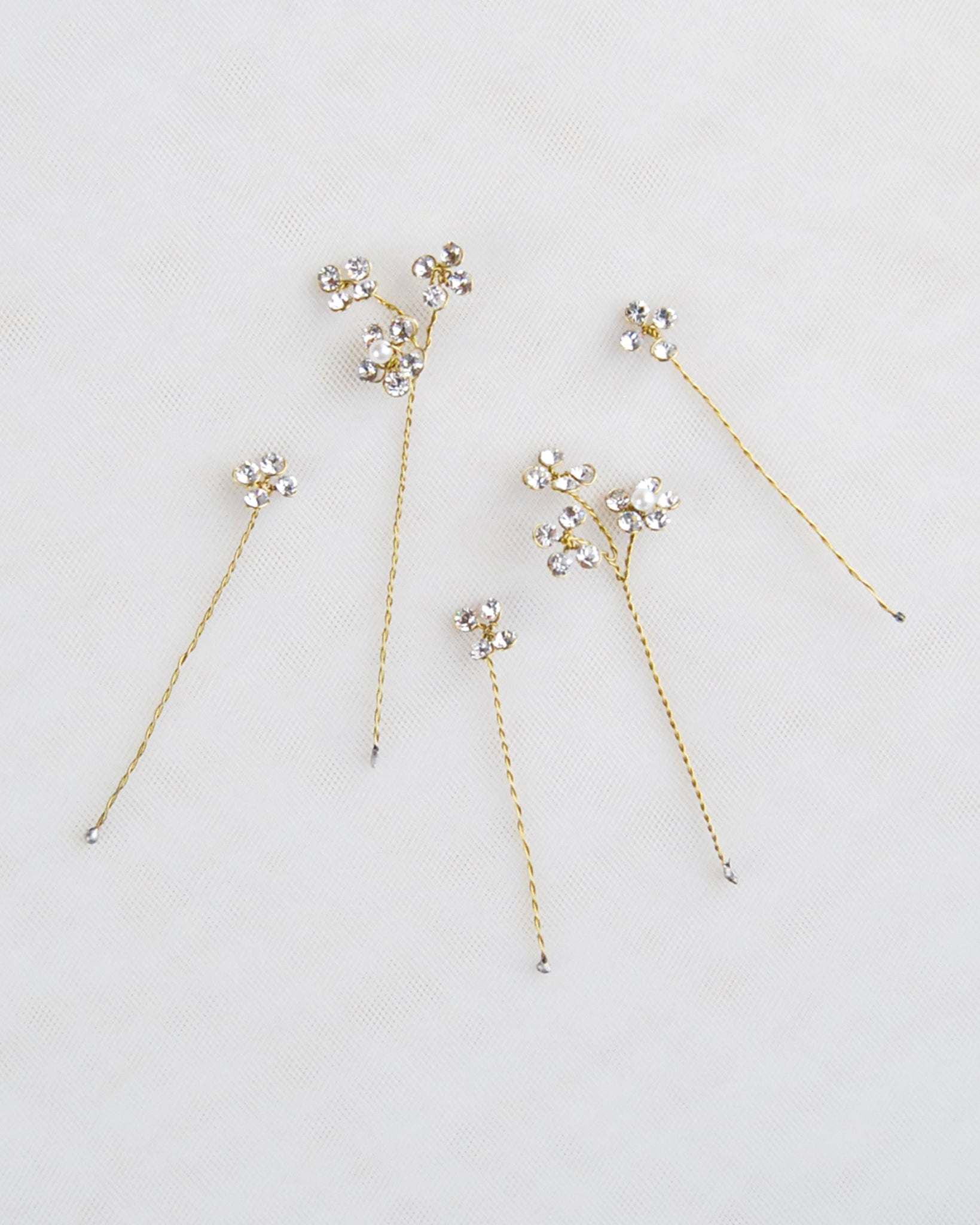 Particolare macro delle forcine Brillaflora con cristalli luminosi e struttura flessibile dorata.