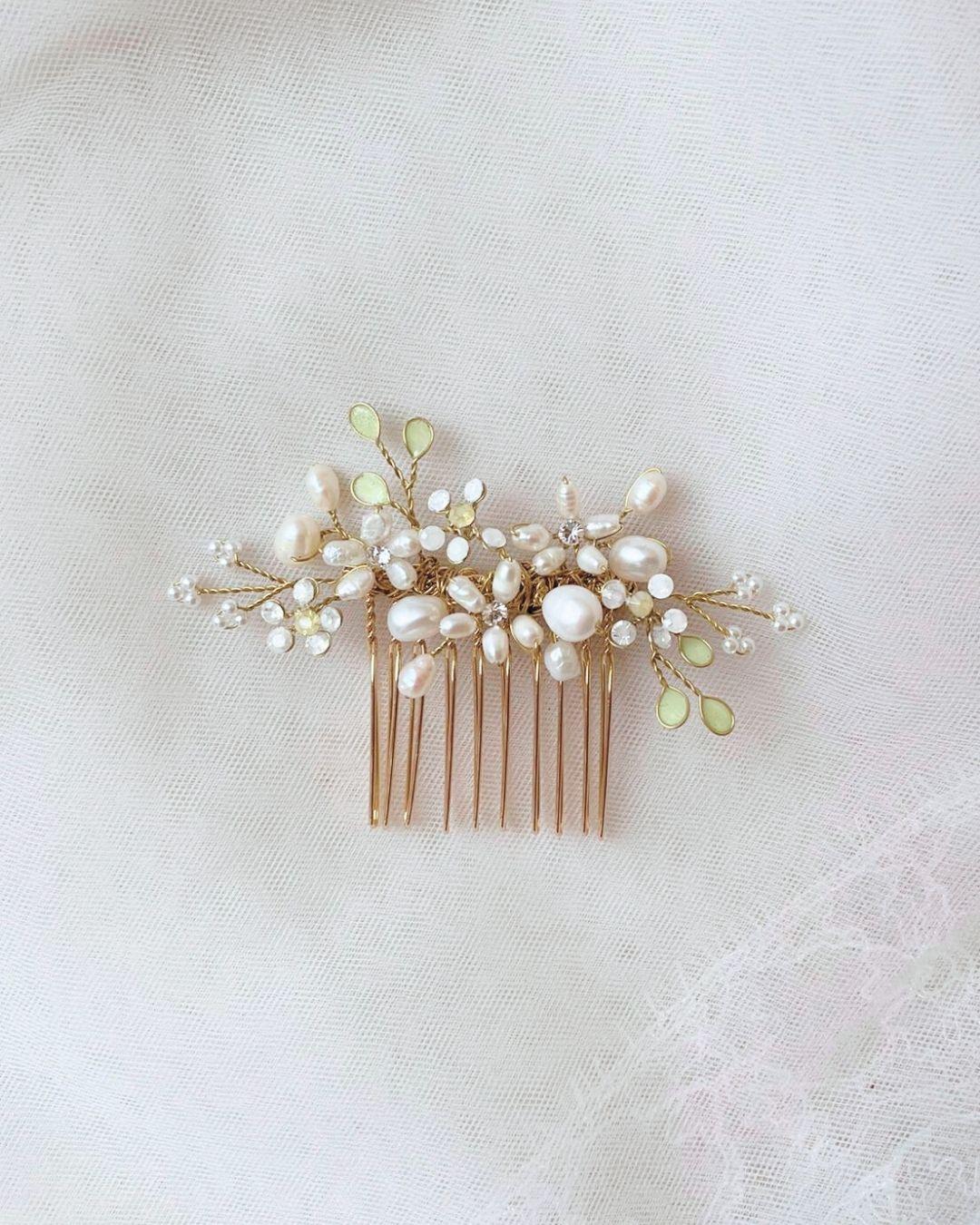 Macro della lavorazione artigianale con perle di fiume e dettagli botanici verdi del pettine Marguerite Lux.