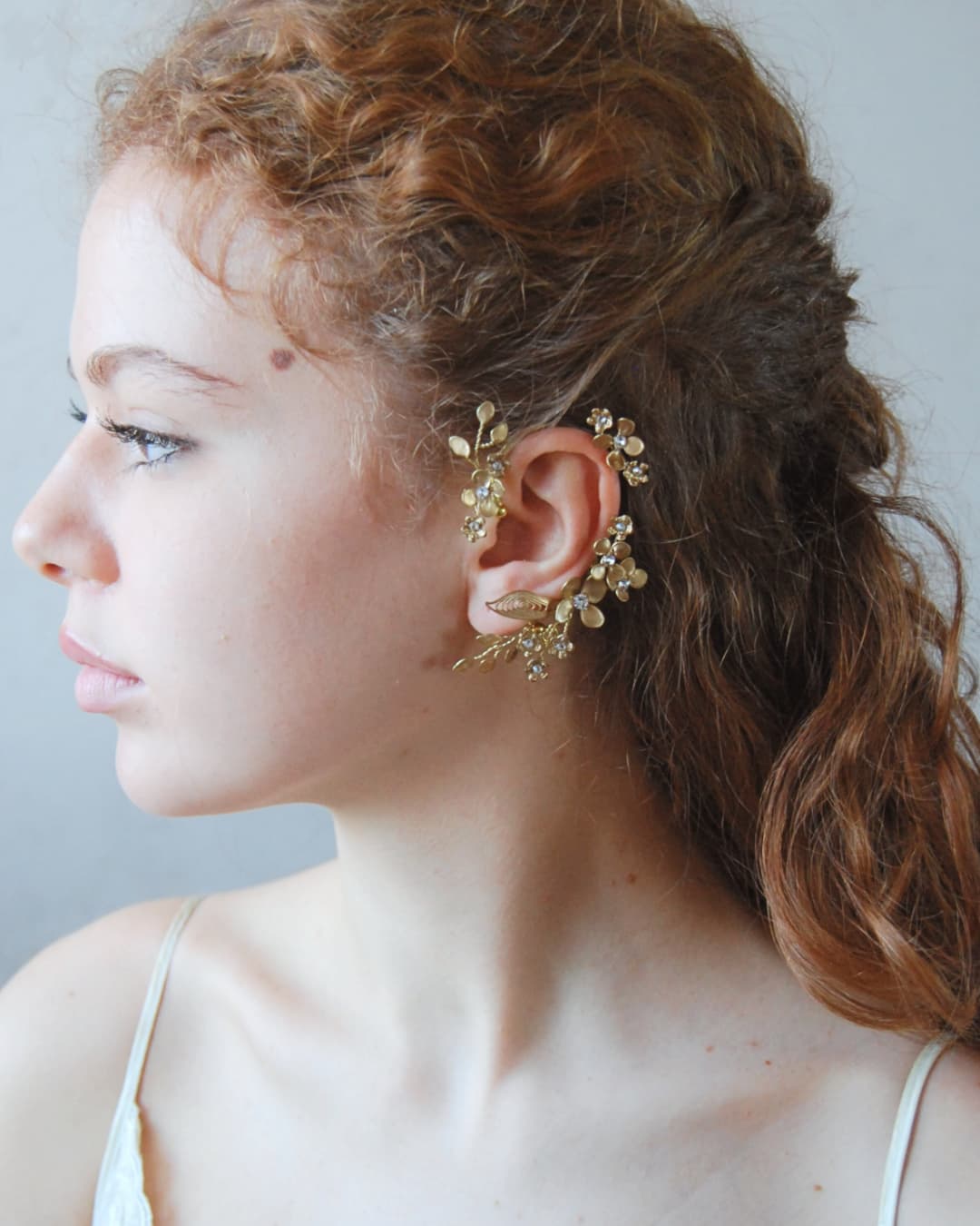 L'ear cuff Aurum indossato, mettendo in risalto un'essenza profondamente femminile e la sua capacità di illuminare il profilo della sposa.