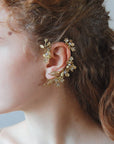 Ear cuff Aurum Elibre: un gioiello scultoreo in oro che avvolge l'orecchio con un design unico per una sposa d'élite.