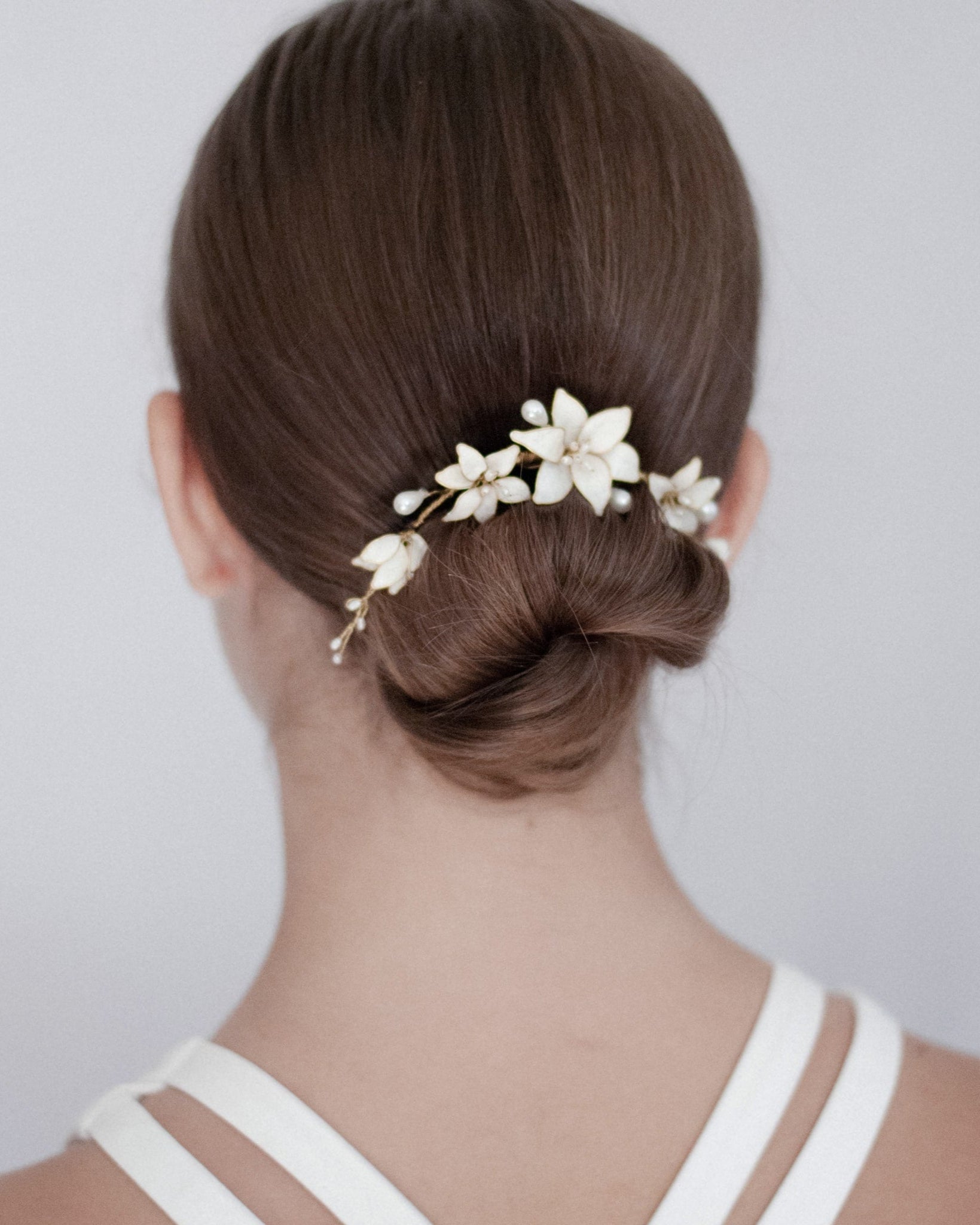 Accessorio moderno con fiori bianchi per acconciature pulite e sofisticate da sposa.