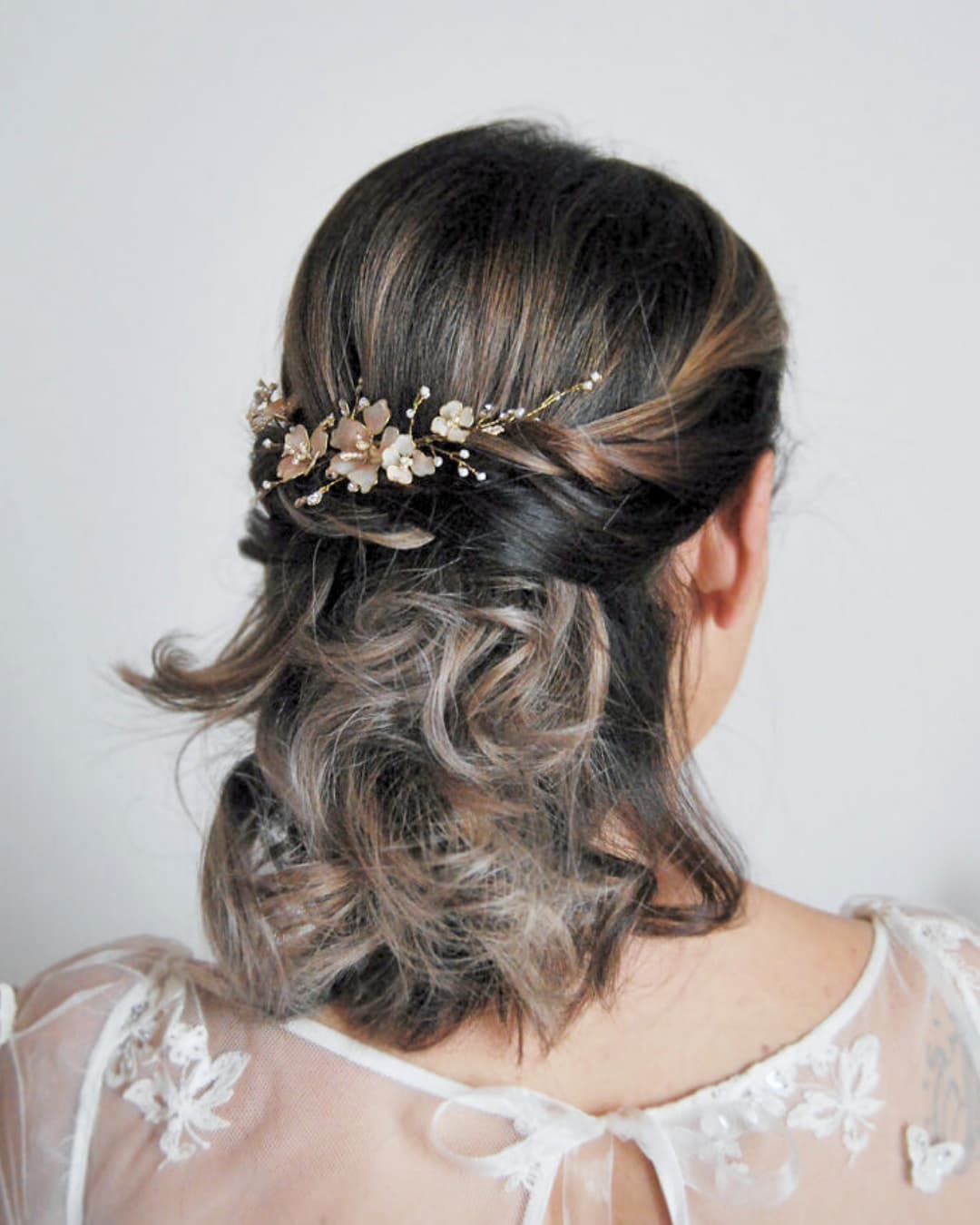 Fermaglio artigianale di lusso ispirato alla fioritura primaverile con petali sfumati e rami dorati.