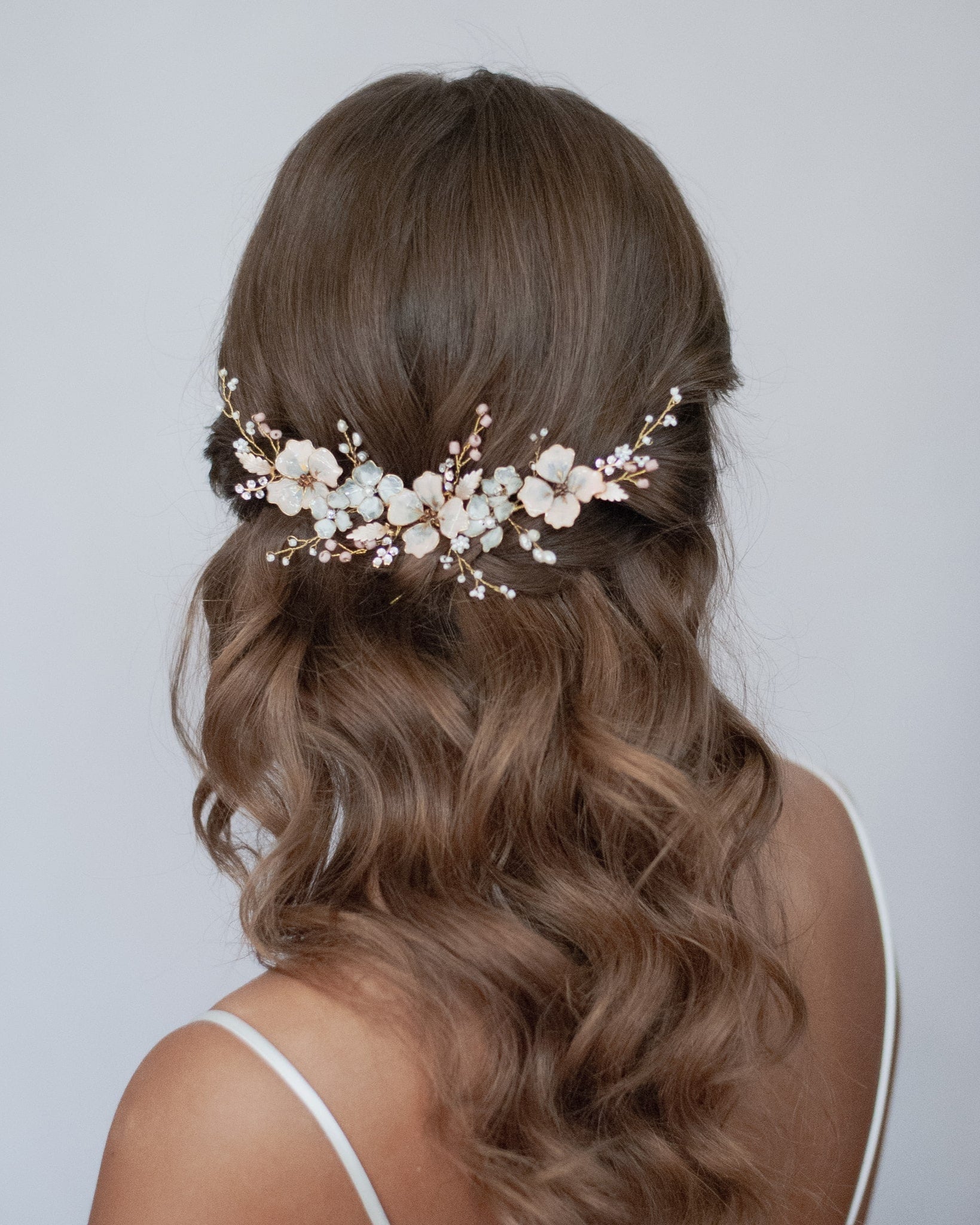 Un accessorio sposa dai dettagli artigianali, con fiori rosa e lavanda per un tocco di colore elegante.
