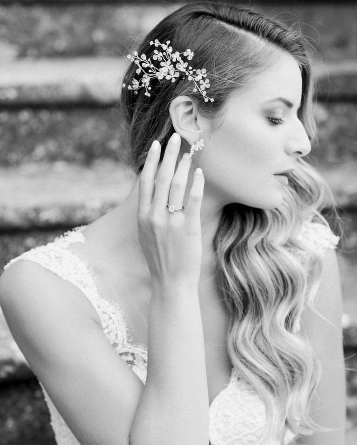 Fermaglio floreale con fiorellini e perle indossato lateralmente su acconciatura da sposa