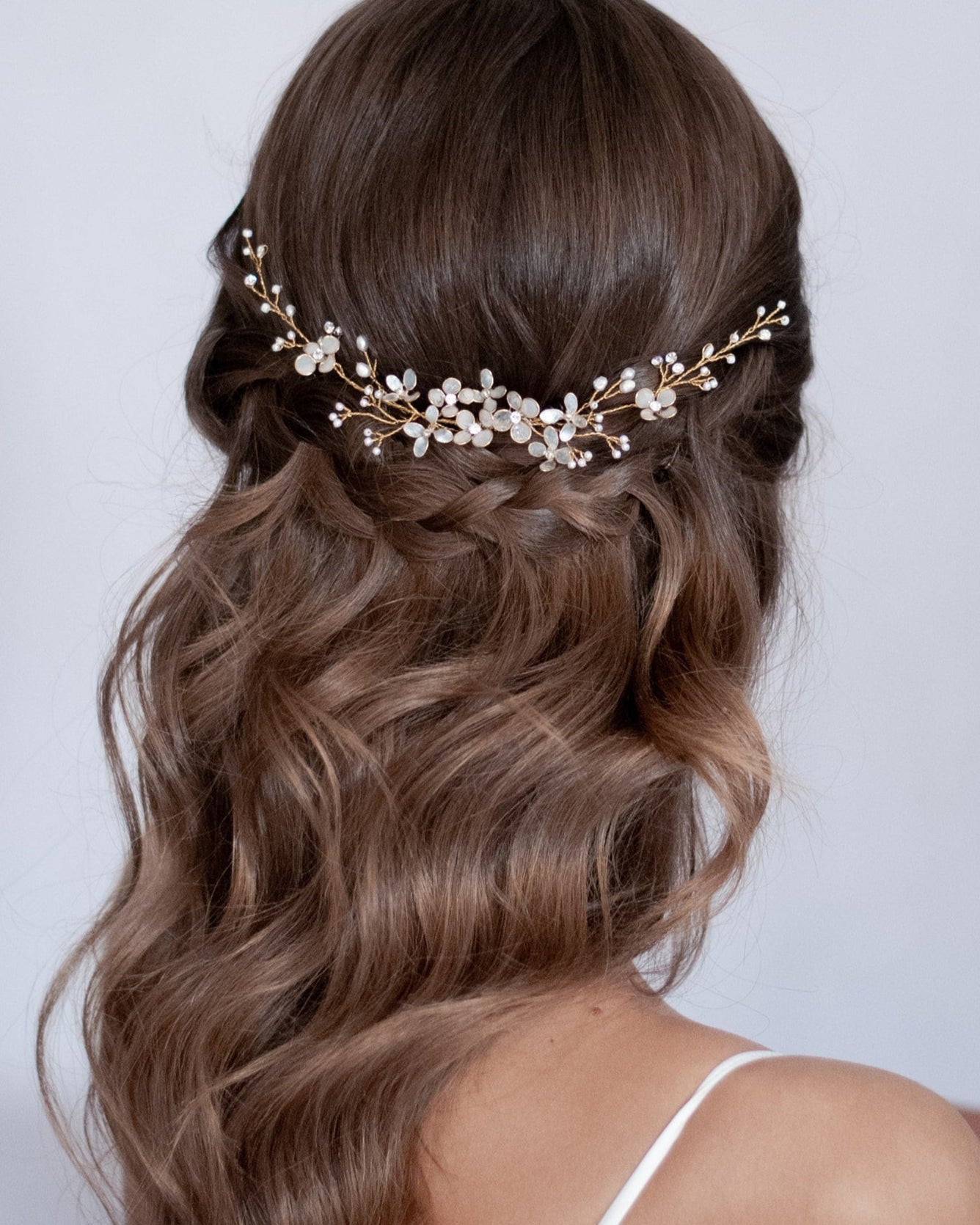 Fermaglio elegante con fiori e perle, ideale per acconciature da sposa luminose e romantiche.