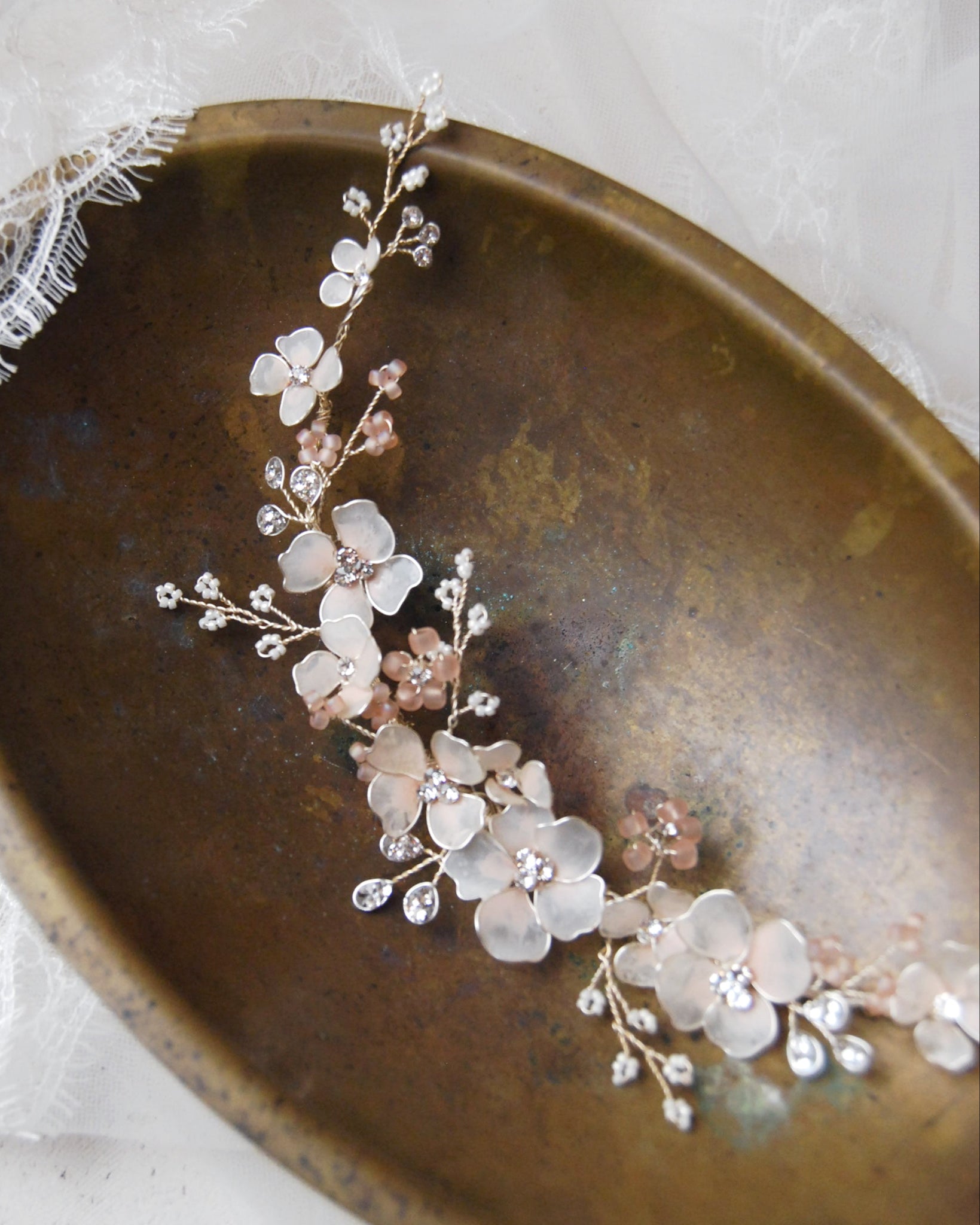 Accessorio da sposa con fermaglio e fiori rosa satinati, un tocco di eleganza per l’acconciatura.