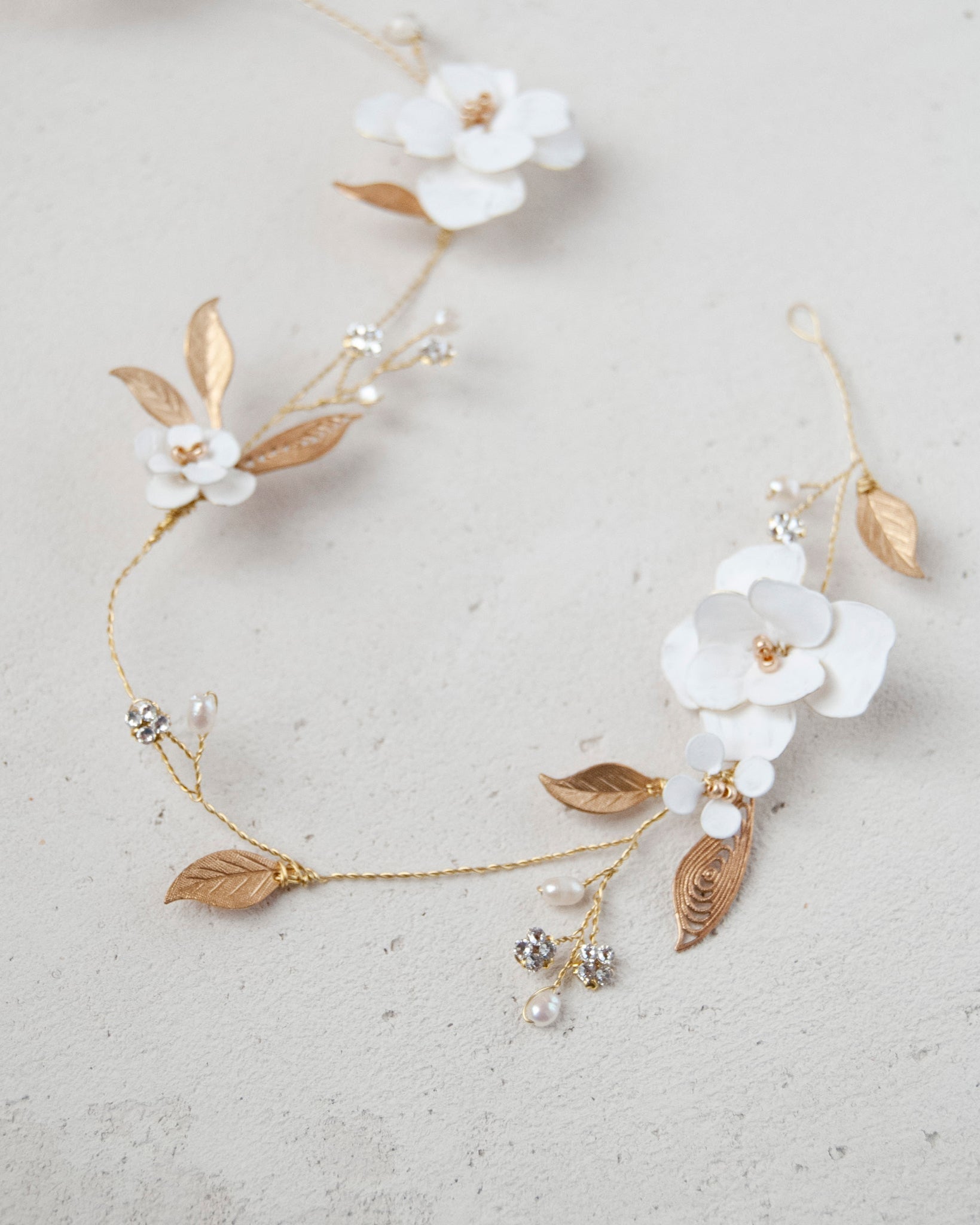 Filo gioiello per capelli con foglie dorate e fiori, ideale per spose moderne ed eleganti.