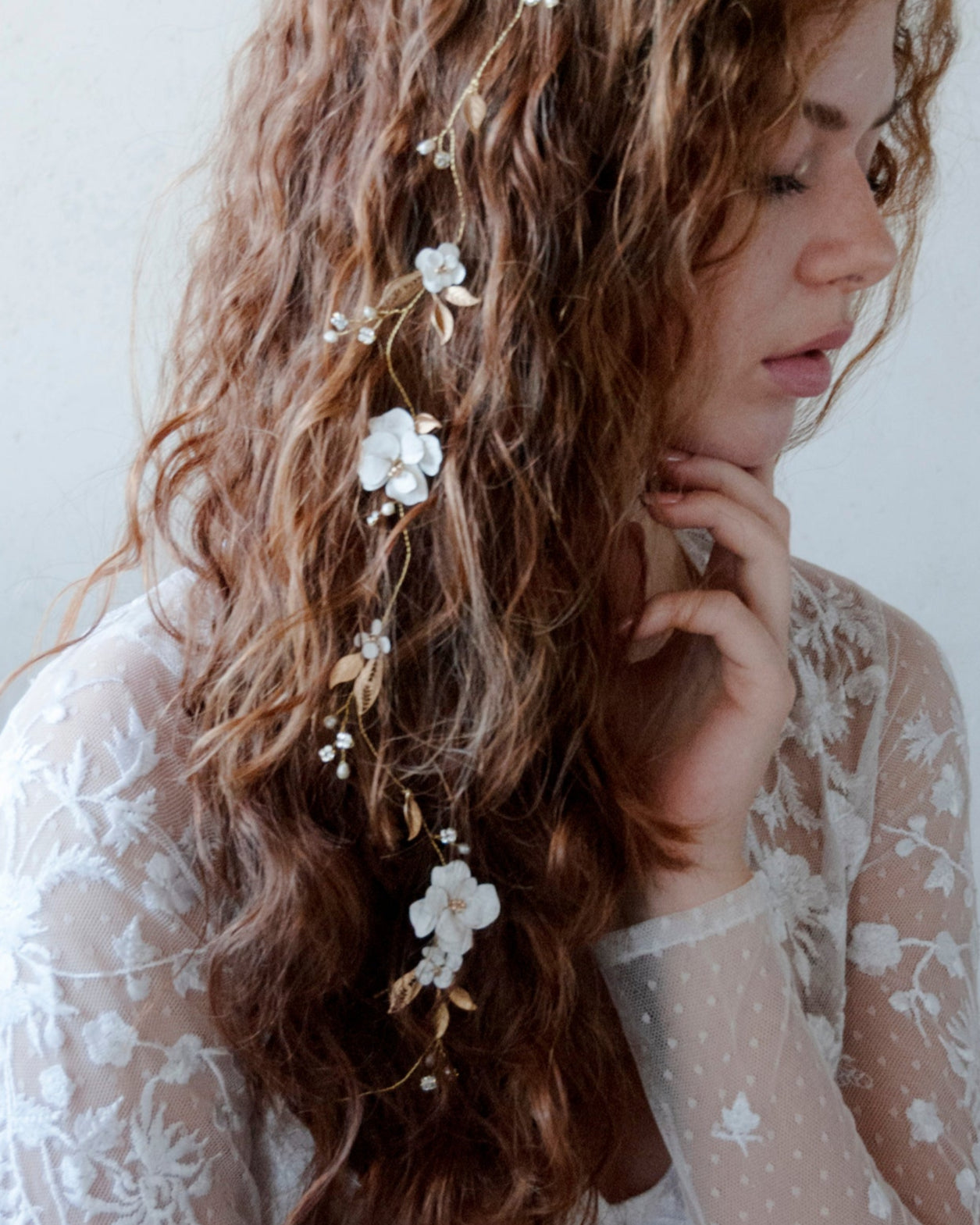 Filo gioiello elegante con fiori e foglie dorate, perfetto per una sposa moderna.