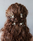 Forcine boho chic per sposa, decorate con fiori e foglie verdi rampicanti, l’accessorio ideale per un matrimonio bohemian.