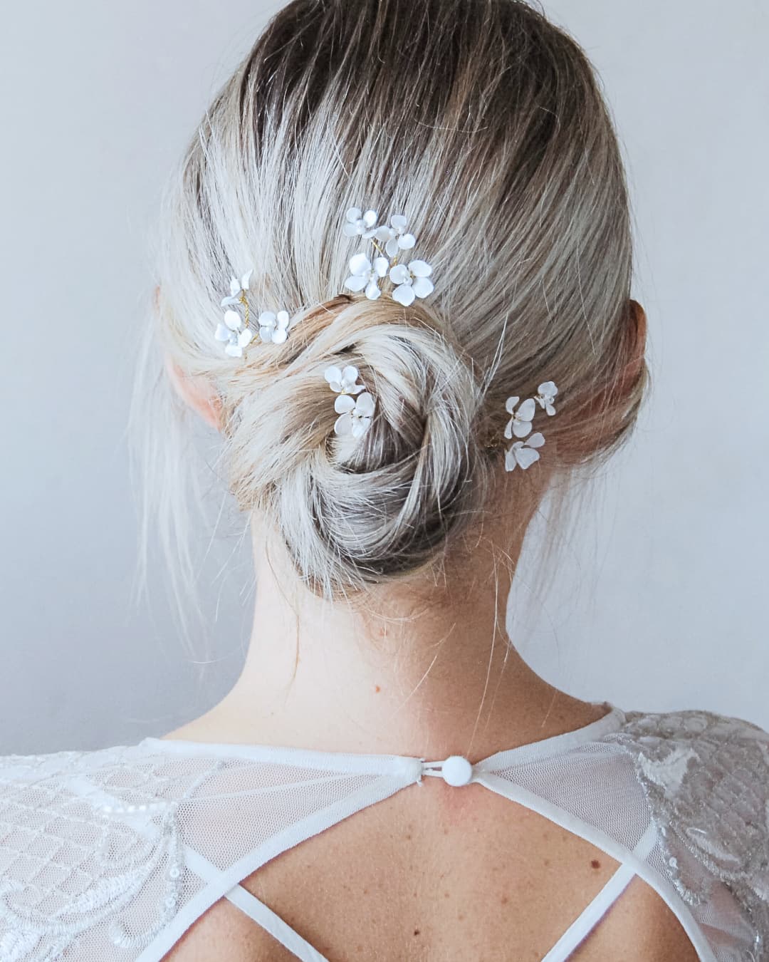 Forcine con piccoli fiori bianchi modellabili per acconciatura sposa boho-chic, ideali da intrecciare in una treccia o un semiraccolto naturale.