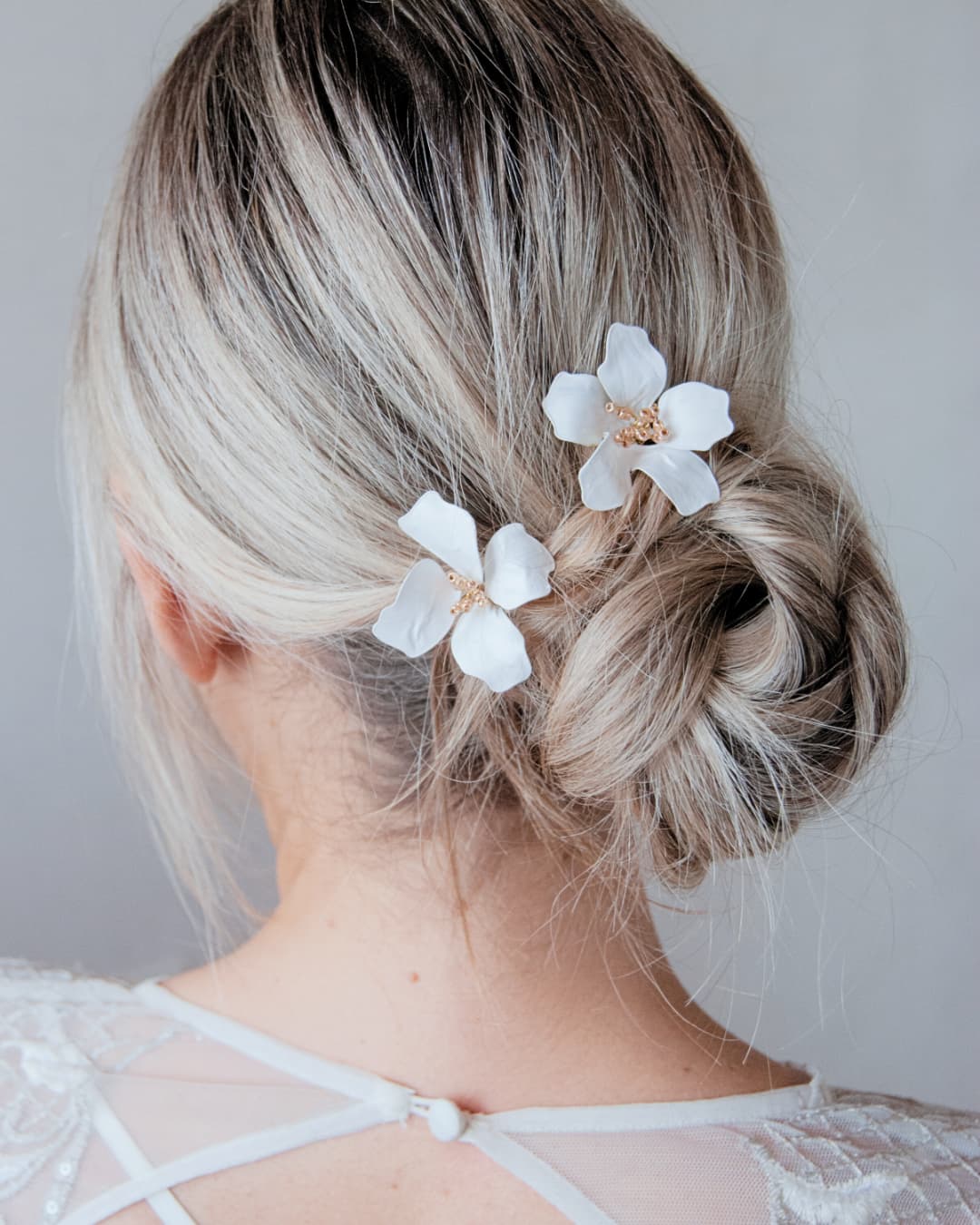Dettaglio forcine artigianali Magnolia Regalia con fiori di magnolia bianchi e oro