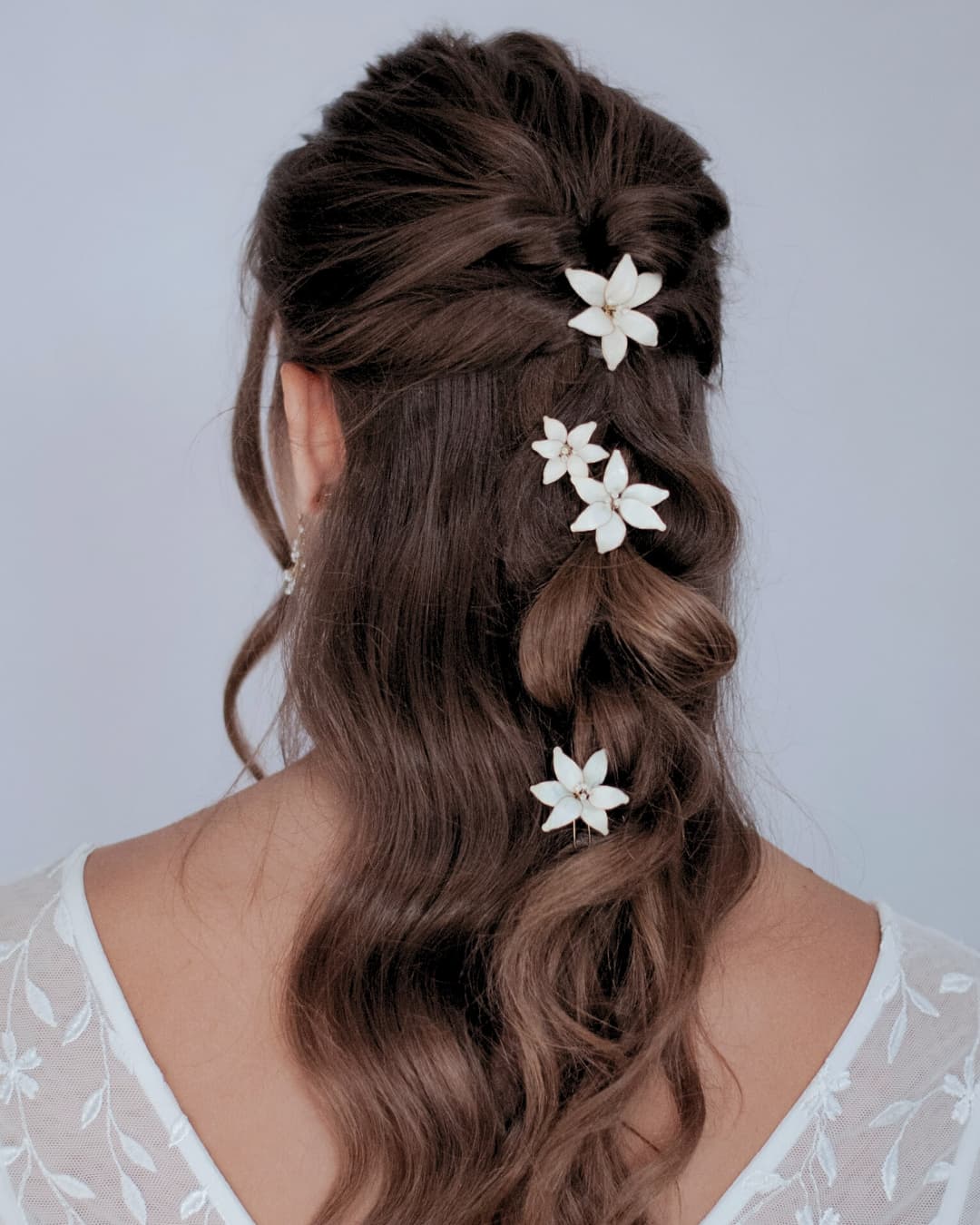 Forcine sposa con giglio bianco su acconciatura raccolta elegante