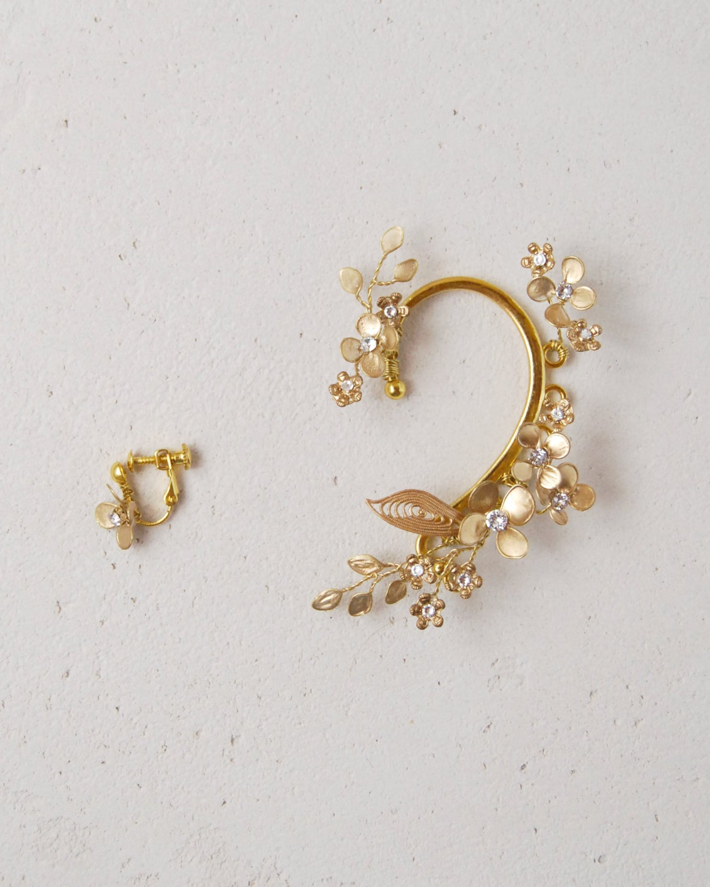 Gioiello da sposa: ear cuff dorato con dettagli floreali raffinati.