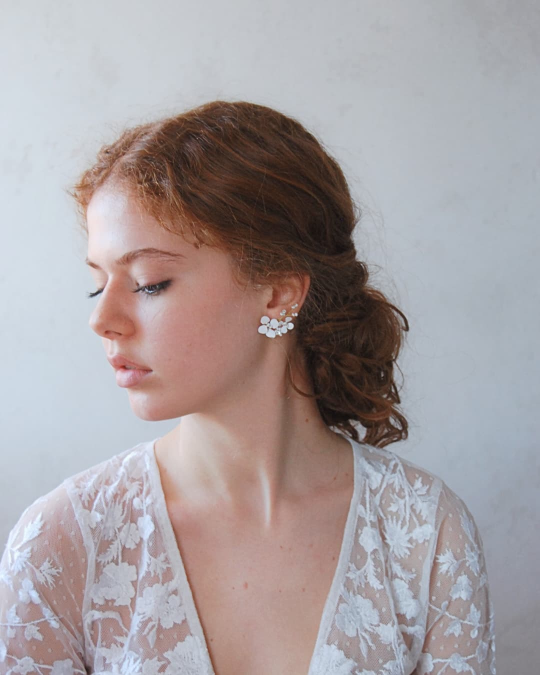 Un'essenza profondamente femminile per gli orecchini climber Biancospino, ideati per illuminare il viso con grazia eterea.