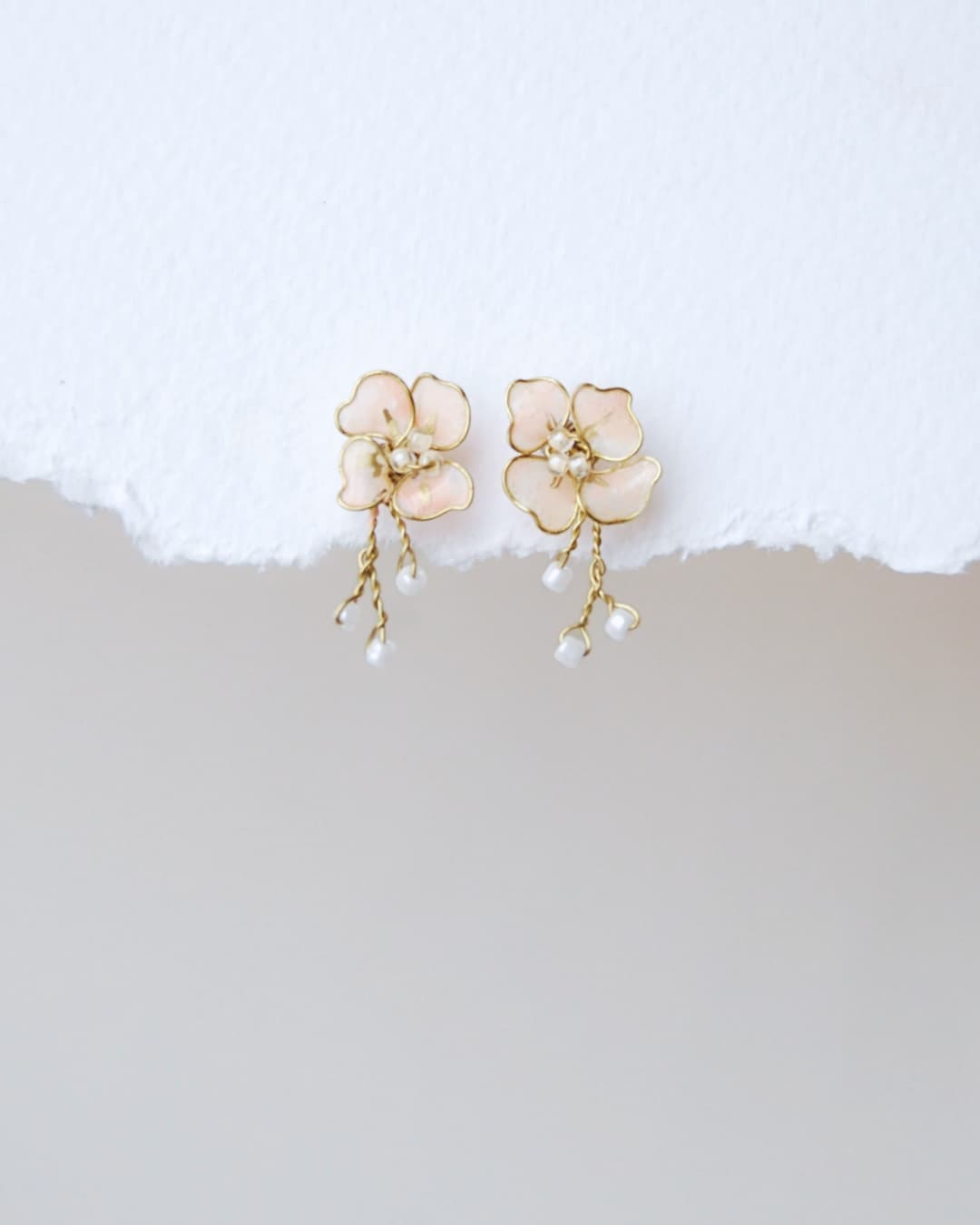 Orecchini sposa Fiori di Ciliegio Elibre con petali bianchi e dettagli pendenti dorati.