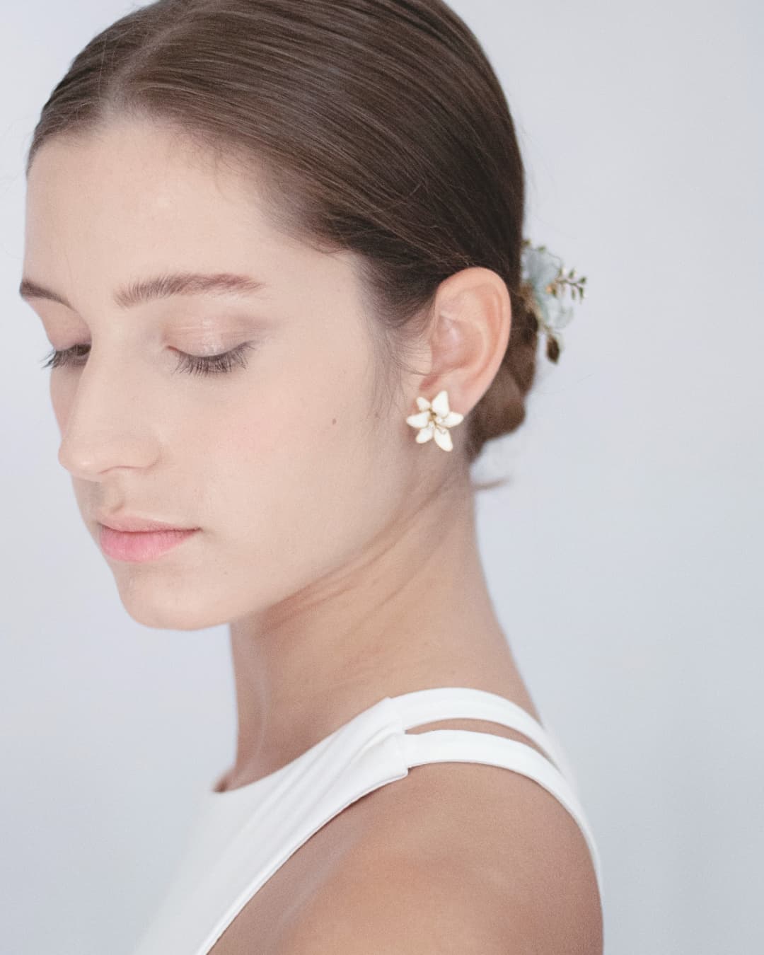 Orecchini a lobo Lilium con fiori bianchi artigianali che incorniciano il volto della sposa con eleganza.