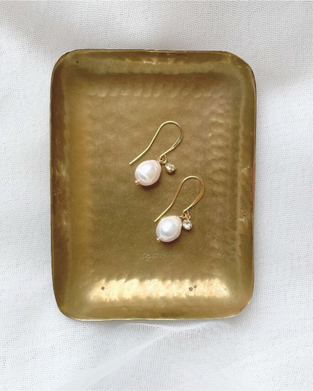 Orecchini pendenti con autentica perla barocca a goccia, un dettaglio di lusso organico per la sposa d'élite.