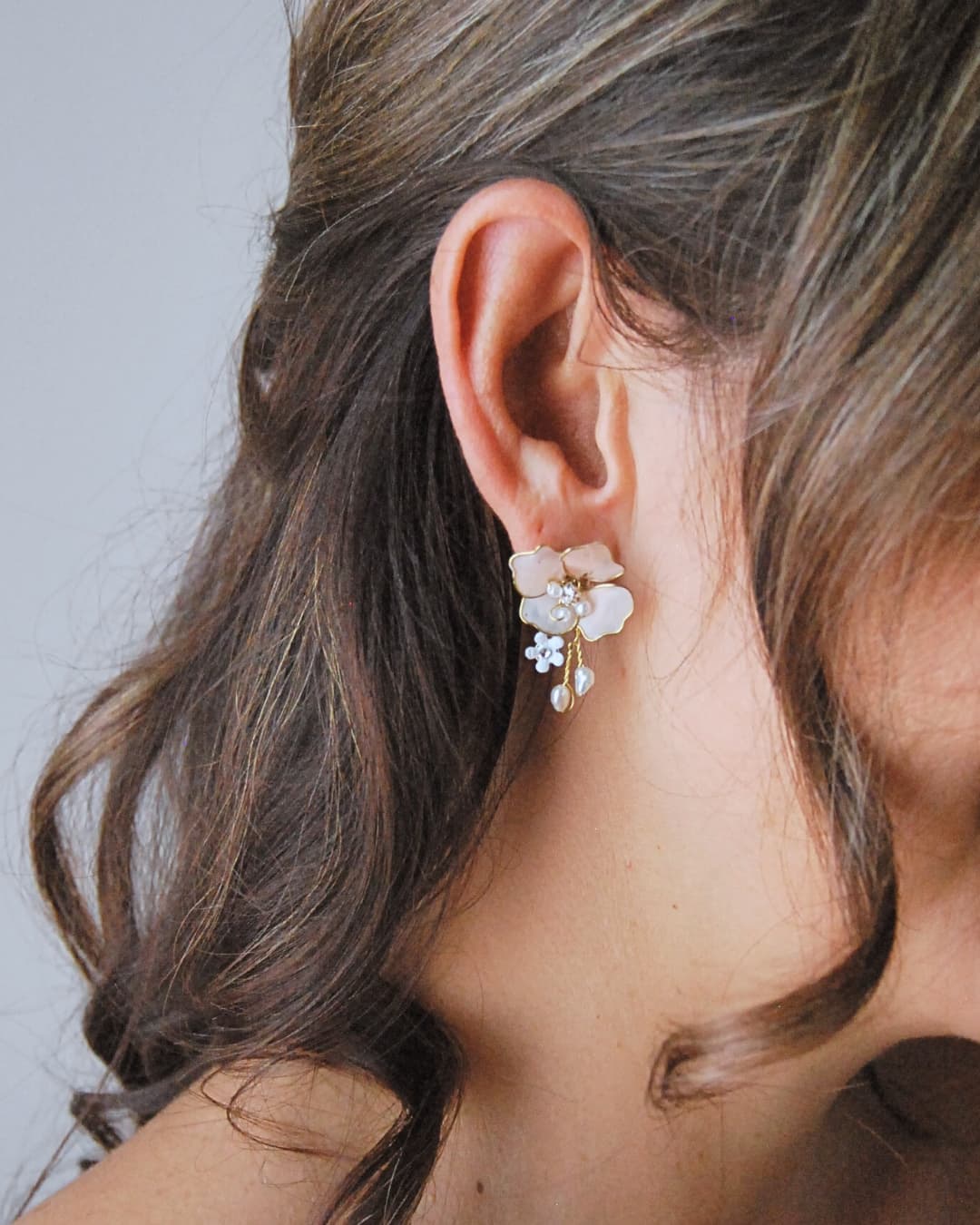 Vista laterale degli orecchini Sakura indossati, evidenziando il design botanico e le delicate sfumature rosa.