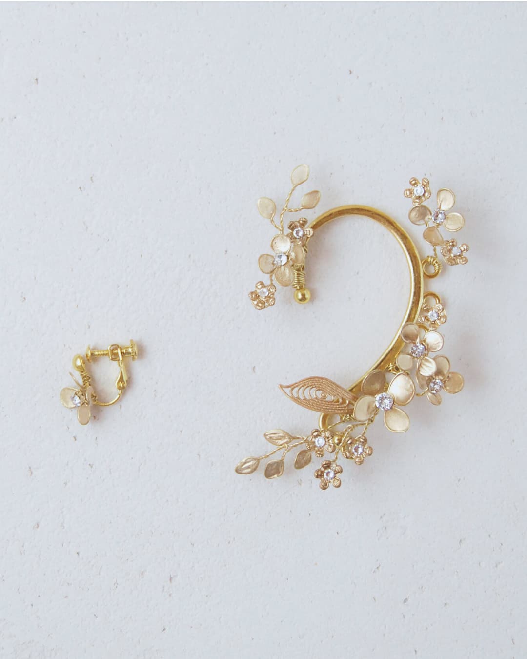 Dettaglio dell'ear cuff Aurum, un accessorio di lusso organico realizzato artigianalmente per un look nuziale moderno e raffinato.