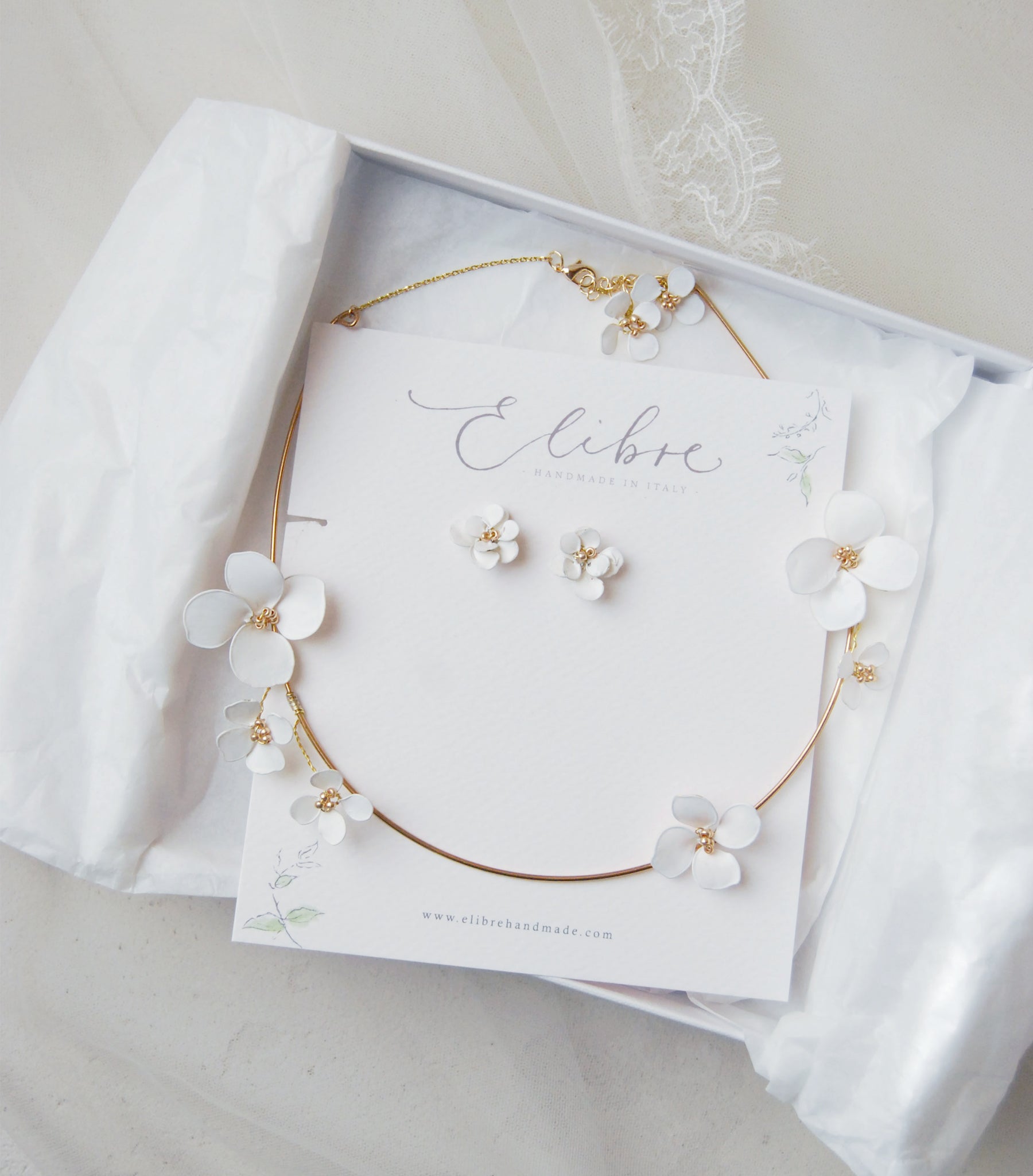 parure da sposa con orecchini e collana di fiori bianchi coordinata per un look nuziale unico.