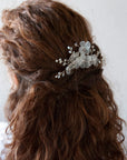 Pettinino per acconciatura da sposa con fiori satinati, per un effetto romantico e chic.