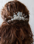 Fiori satinati su pettinino, ideale per un look da sposa elegante e luminoso.