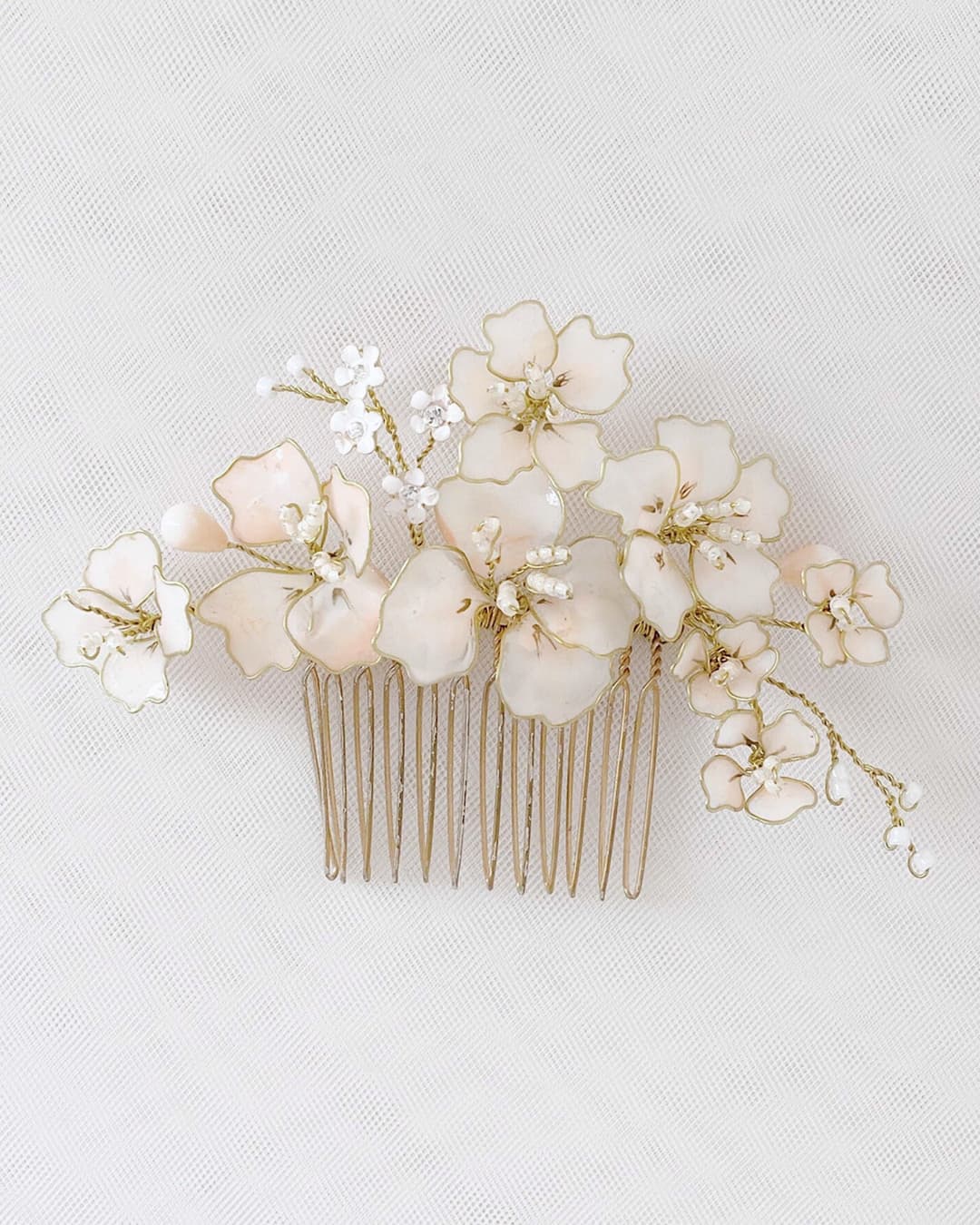 Pettinino sposa Elibre con composizione di fiori di ciliegio rosa cipria e rami dorati.