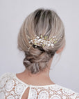 Pettinino sposa con fiori in pizzo, cristalli e foglioline verdi per un look romantico e incantevole.