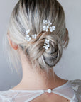 Set di forcine con fiorellini bianchi, ideale per acconciature da sposa raffinate.