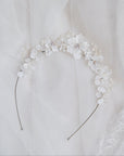 Tiara floreale con dettagli satinati bianchi, un accessorio chic per spose eleganti.