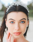 Tiara con fiori bianchi satinati, cristalli Swarovski e perline, l’accessorio perfetto per spose che desiderano un look chic e luminoso.